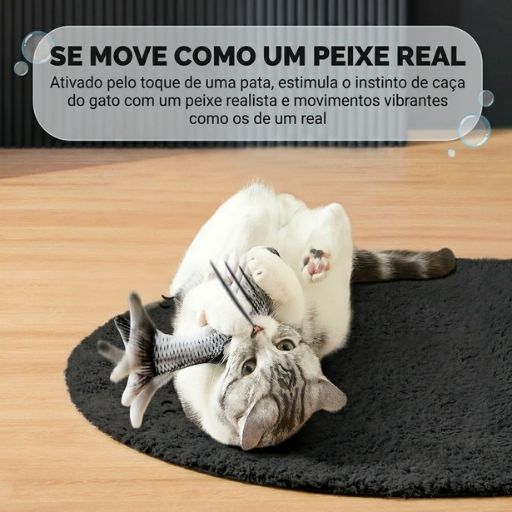 Gato deitado de barriga para cima, a agarrar o brinquedo de peixe realista com as patas, ativando o mecanismo de movimento através do toque.